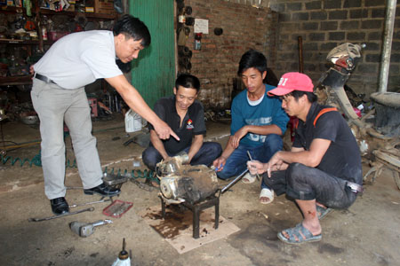 Giáo viên Trung tâm DNVGDTX huyện Trạm Tấu hướng dẫn học nghề sửa chữa xe máy cho học viên.